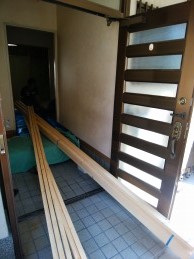 畳と隣の部屋との段差をなくすための下地の補強木材を玄関から運び入れ 畳と隣の部屋との段差をなくすための下地の補強木材を玄関から運び入れ